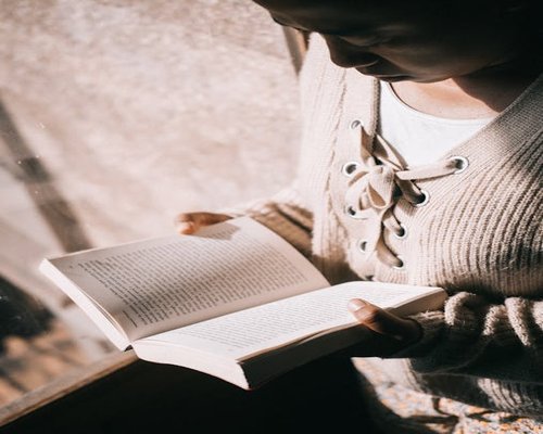 Person reading a book quietly indoors