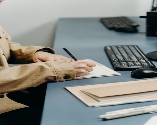 Person writing in a notebook on a desk